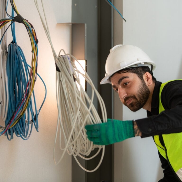Construction worker is examining cables at a construction site.
